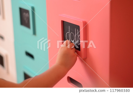 Child's hand signing a toy box 117960380