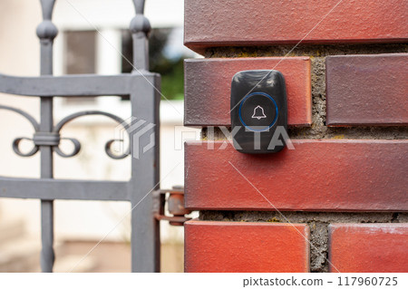 Close-Up of Hand Pressing a Wireless Doorbell 117960725