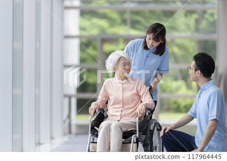 Smiling senior woman and care staff having a conversation 117964445