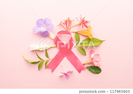 Pink ribbon awareness symbol with flowers for supporting breast cancer patient on pink background. Breast Cancer Awareness Month in October. Women's health care. Pink ribbon awareness symbol with flowers for supporting breast cancer patient on pink background. Breast Cancer Awareness Month in October. Women's health care. 117965603