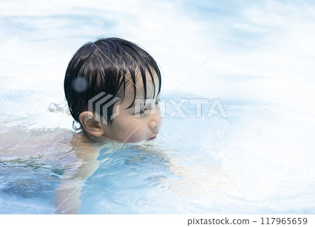 Girl enjoying splashing around in the pool 117965659
