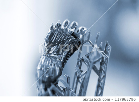Model of leg printed on a 3D printer from black rubber, close-up. Part of an object created on a 3D printer from hardened rubber under the influence of ultraviolet light. SLA 3D printing technology. Model of leg printed on a 3D printer from black rubber, close-up. Part of an object created on a 3D printer from hardened rubber under the influence of ultraviolet light. SLA 3D printing technology. 117965796