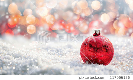 Christmas backdrop featuring a Christmas ball and snow on a glitter bokeh background. with copy space image. Place for adding text or design 117966126