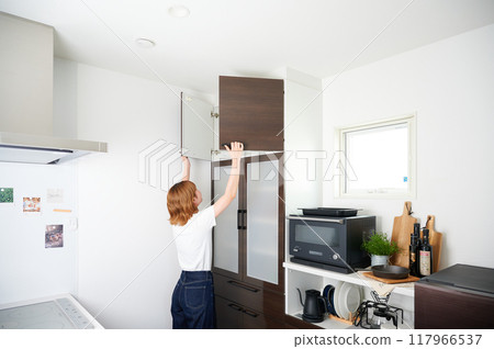 Woman opening cupboard, housewife, housework, cooking, cleaning up Woman opening cupboard, housewife, housework, cooking, cleaning up 117966537