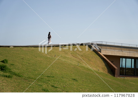 Back view of a woman walking along Komuroyama Ridge Walk Back view of a woman walking along Komuroyama Ridge Walk 117967828