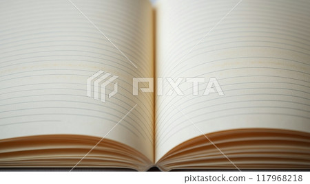 An open notebook rests on a wooden table, ready for thoughts and ideas on a quiet afternoon 117968218