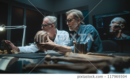 Two archaeologists measures fossil skull, use tablet computer 117969304