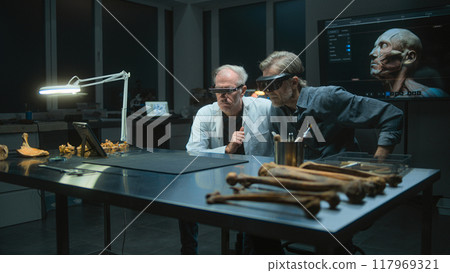 Two archaeologists in virtual reality headsets conduct historical research, have discussion Two archaeologists in virtual reality headsets conduct historical research, have discussion 117969321