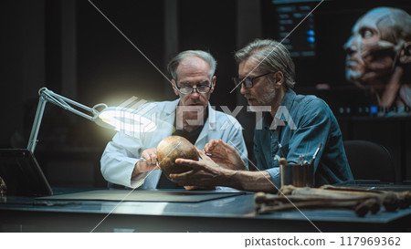 Two archaeologists study fossil remains, use tablet computer 117969362