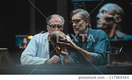 Two archaeologists conduct scientific research on prehistoric human skull Two archaeologists conduct scientific research on prehistoric human skull 117969364