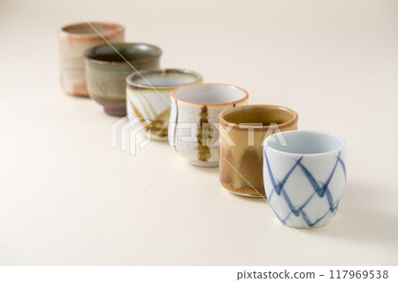 Several types of sake cups on a light gold background Several types of sake cups on a light gold background 117969538