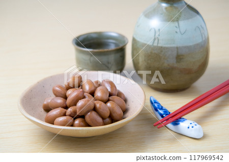 木紋背景小盤子上放著煮熟的花生和酒精 117969542
