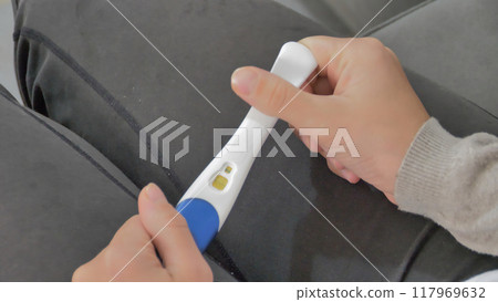 Close-up of male hands holding a pregnancy test 117969632