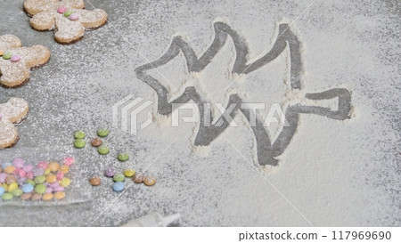 a child's hand draws a Christmas tree in flour a child's hand draws a Christmas tree in flour 117969690