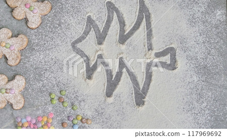 a child's hand draws a Christmas tree in flour a child's hand draws a Christmas tree in flour 117969692