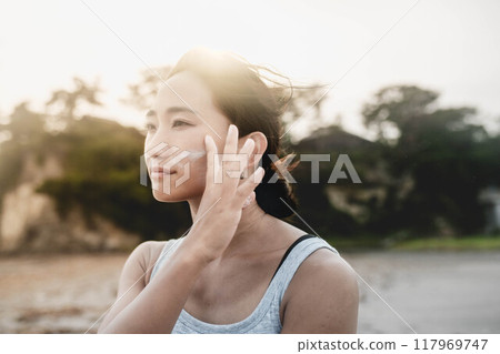日本年輕女性在海邊做皮膚護理 日本年輕女性在海邊做皮膚護理 117969747