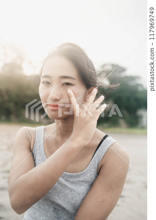 Young Japanese woman doing skin care at the beach 117969749