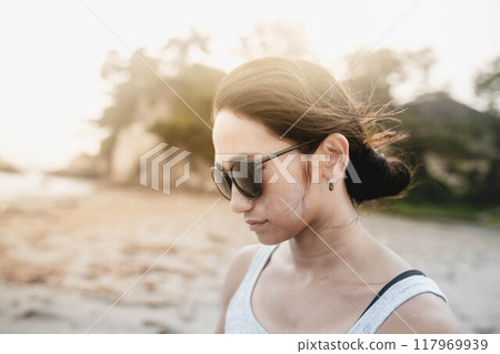 在多風的沙灘上戴墨鏡的日本年輕女子 117969939
