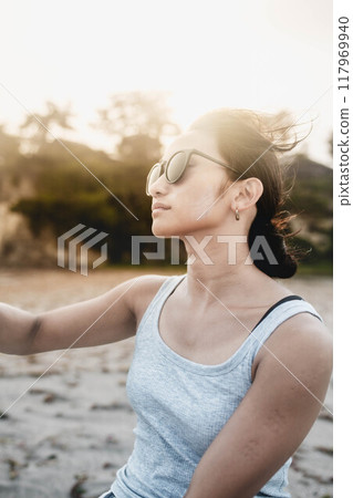 在多風的沙灘上戴墨鏡的日本年輕女子 117969940