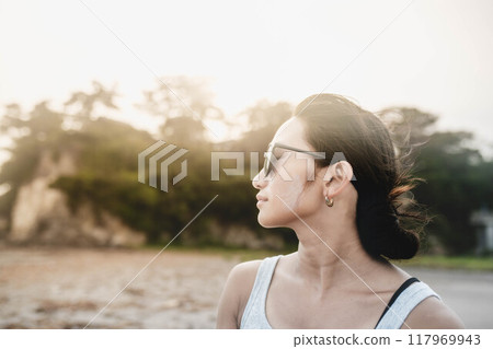 在多風的沙灘上戴墨鏡的日本年輕女子 在多風的沙灘上戴墨鏡的日本年輕女子 117969943