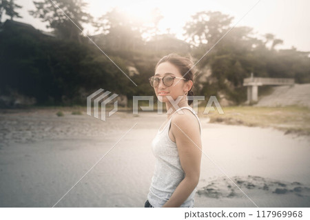 在多風的沙灘上戴墨鏡的日本年輕女子 117969968