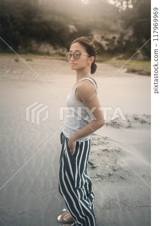 在多風的沙灘上戴墨鏡的日本年輕女子 117969969
