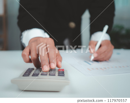 Businesswoman in black suit working on laptop computer and tablet and calculator, Hand Hands touch on tablet at office with dark background, Online working, Close up, Copy space. Businesswoman in black suit working on laptop computer and tablet and calculator, Hand Hands touch on tablet at office with dark background, Online working, Close up, Copy space. 117970557