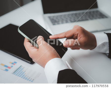 Woman using mobile phone on office table. Business woman surfing the internet, Searching the information on smartphone, Freelancer online working, Using smartphone surfing the internet, remote work. 117970558