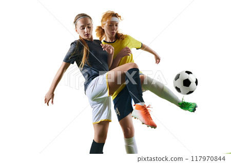 Athletic young women, mid-20s, soccer players, both battling for ball possession, with one player successfully blocking other on green field. Athletic young women, mid-20s, soccer players, both battling for ball possession, with one player successfully blocking other on green field. 117970844