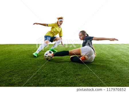 Young athletic woman, mid-20s, executing powerful flying kick towards ball, showcasing agility and precision on soccer field. 117970852