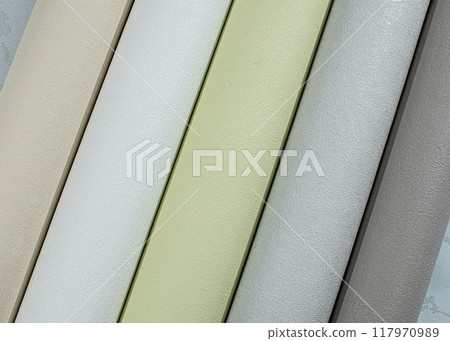 Multi-colored tubes of paper wallpaper for repairs rolled into rolls. 117970989