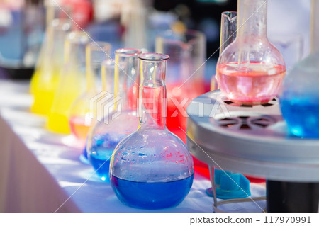 Transparent laboratory flask with multi-colored liquid or chemical solution. 117970991