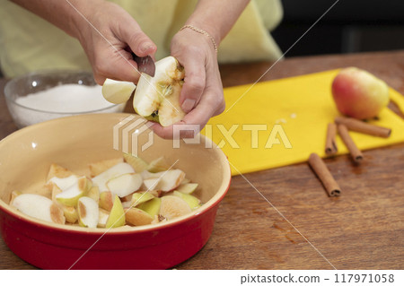 Hands cutting apples with a knife. Cooking apple pie. Hands cutting apples with a knife. Cooking apple pie. 117971058