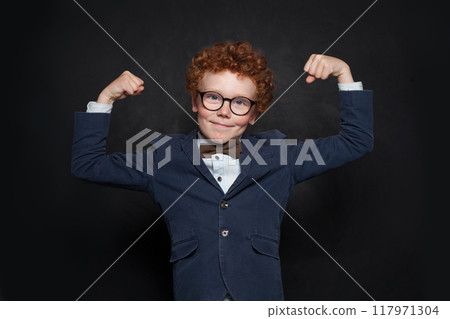 Funny strong successful child boy showing his muscles. Little kid boy power concept. Funny strong successful child boy showing his muscles. Little kid boy power concept. 117971304