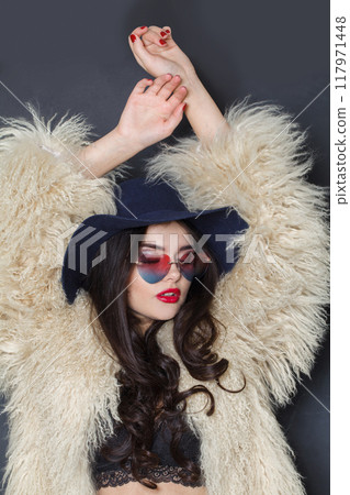 Dancing fashion model woman in blue classic hat and white fur coat posing indoor 117971448