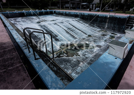 A damaged pool with no water, a deep creepy swimming hole, an abandoned diving pool, 117972920