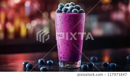 Delicious berry smoothie topped with fresh blueberries in a glass at a cozy cafe in the evening 117973847