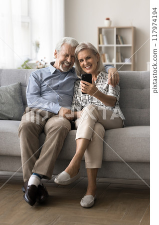 Attractive mature spouses spend pleasant time on internet using smartphone 117974194