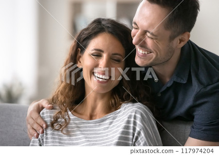 Cheerful husband hugs beautiful wife, joking, giggling, feel happy Cheerful husband hugs beautiful wife, joking, giggling, feel happy 117974204