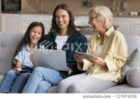 Joyful grandmother, happy mom and adorable kid girl using gadgets 117974209