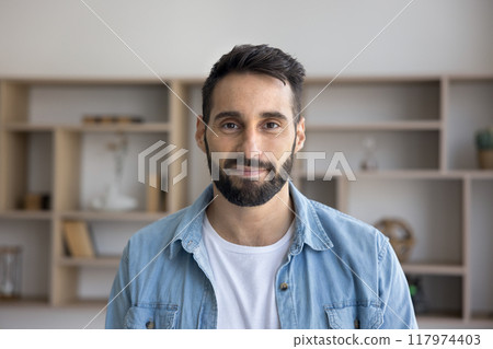 Positive handsome young Latin entrepreneur man standing for head shot 117974403