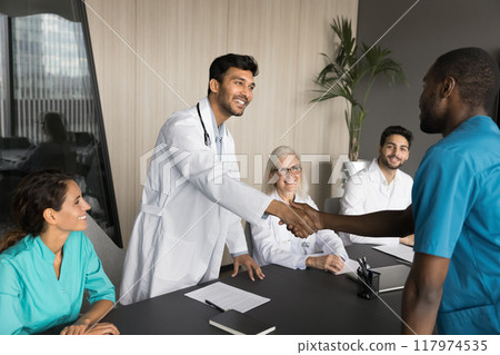 Young Indian doctor wear white coat greeting seminar participant Young Indian doctor wear white coat greeting seminar participant 117974535