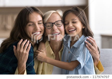 Happy sweet loving granddaughter kid and young mom hugging grandma 117974707
