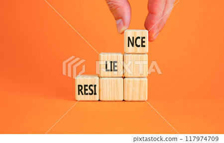 Resilience symbol. Concept word Resilience on beautiful wooden blocks. Businessman hand. Beautiful orange background. Business resilience concept. Copy space. Resilience symbol. Concept word Resilience on beautiful wooden blocks. Businessman hand. Beautiful orange background. Business resilience concept. Copy space. 117974709