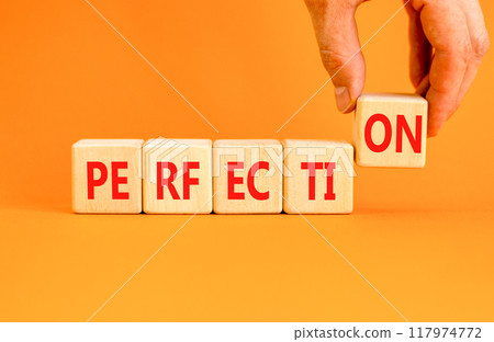 Perfection symbol. Concept word Perfection on beautiful wooden blocks. Beautiful orange background. Businessman hand. Business perfection concept. Copy space. Perfection symbol. Concept word Perfection on beautiful wooden blocks. Beautiful orange background. Businessman hand. Business perfection concept. Copy space. 117974772