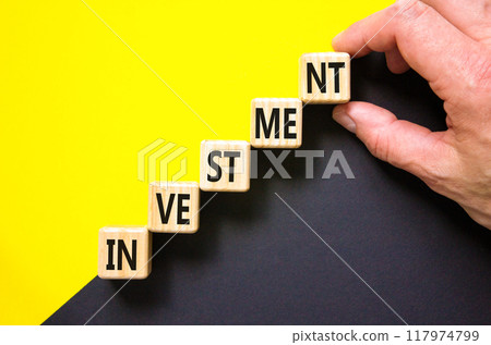 Investment symbol. Concept word Investment on beautiful wooden cubes. Beautiful yellow and black background. Businessman hand. Business investment concept. Copy space. Investment symbol. Concept word Investment on beautiful wooden cubes. Beautiful yellow and black background. Businessman hand. Business investment concept. Copy space. 117974799