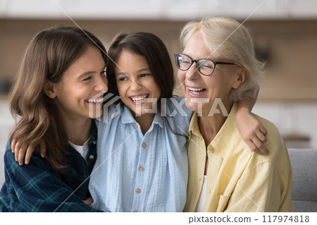 Happy child girl embracing beloved mom and grandma with love 117974818