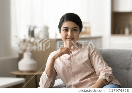Portrait of relaxed woman sit on couch look at camera Portrait of relaxed woman sit on couch look at camera 117974828