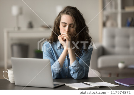 Tired student resting seated at table, relieving fatigue, feels unmotivated 117974871