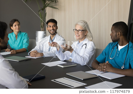 Group of diverse interns listening speech of older woman therapist 117974879